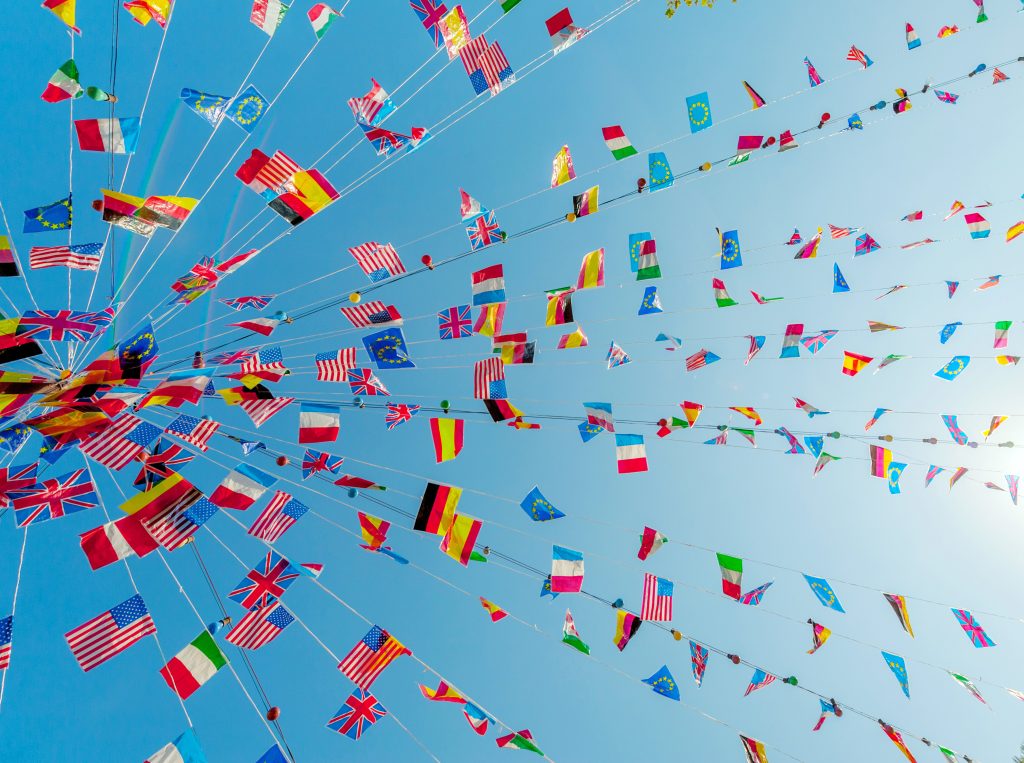 International flags blowing against the sky in a clear summer afternoon